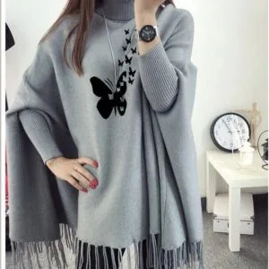 Lifestyle image of model wearing grey butterfly poncho outdoors