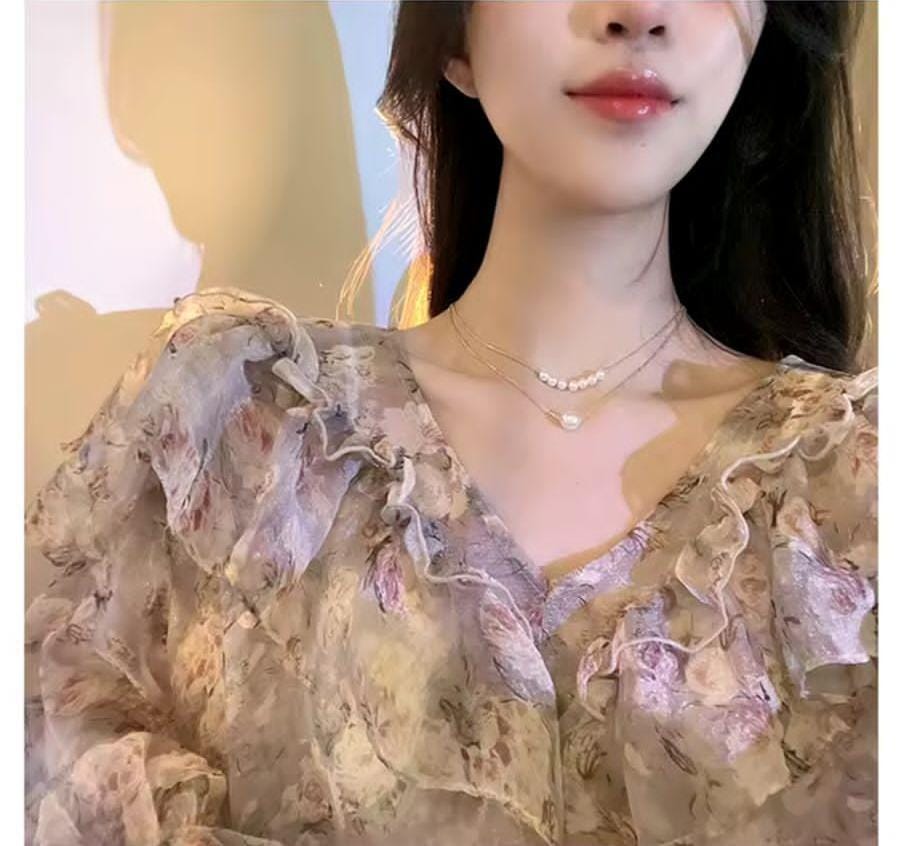 Lifestyle image of model wearing 2 layered pearl necklace