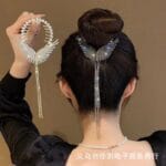 Model styling hair with butterfly design silver hair claw
