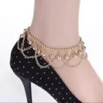 Model wearing bell gold plated anklet with traditional dress