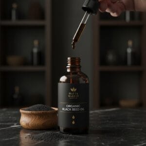 Black seed oil bottle with kalonji seeds around – herbal oil